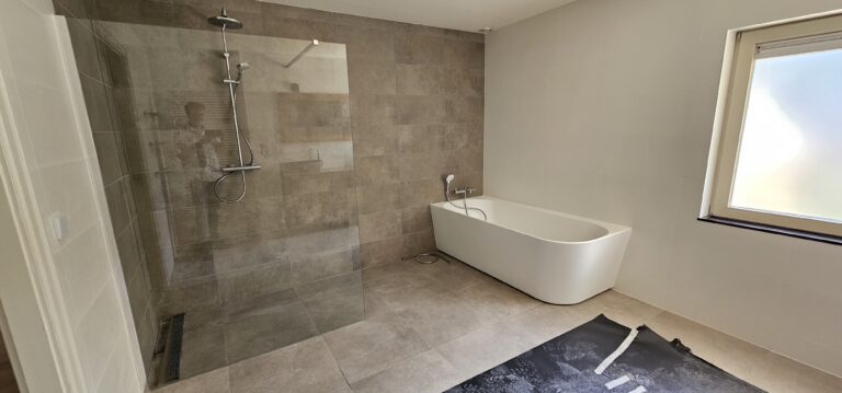 Ruime badkamer met inloopdouche en vrijstaand bad